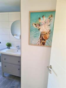 ein Badezimmer mit einem Gemälde einer Giraffe in der Unterkunft Pferdeglück Pappenheimer in Oettingen in Bayern