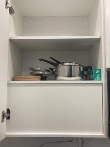 une armoire blanche avec un pot et des casseroles dans l'établissement Ensanche Apartments, à Madrid