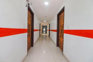 FabExpress Abode Inn في نيودلهي: ممر في مبنى به جدران حمراء وبيضاء