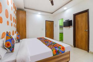 - une chambre avec un lit et une télévision dans l'établissement FabExpress Abode Inn, à New Delhi