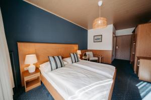 1 dormitorio con 1 cama grande y pared azul en Hotel Greif en Sankt Kanzian