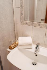 a white bathroom sink with a towel on it at Hotel Greif in Sankt Kanzian