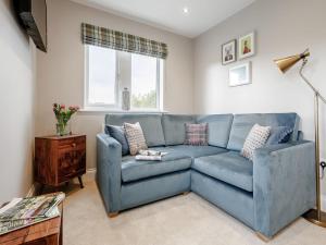 a blue couch in a living room with a window at 2 Bed in Holmfirth 82193 in Meltham