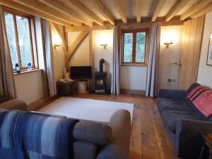 a living room with a couch and a stove at Oakenhurst in Fowey