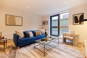 sala de estar con sofá azul y mesa en The Putney Escape - Trendy 2BDR Flat with Terrace + Parking en Londres