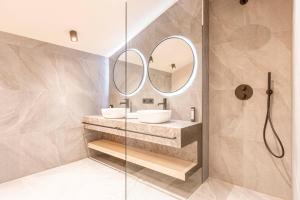 uma casa de banho com um lavatório e um espelho em Kitzbühel Suites by ALPS RESORTS em Oberndorf in Tirol
