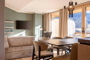 a living room with a table and chairs and a couch at Kitzbühel Suites by ALPS RESORTS in Oberndorf in Tirol