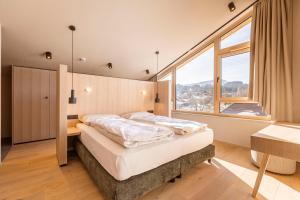 1 dormitorio con cama y ventana grande en Kitzbühel Suites by ALPS RESORTS, en Oberndorf in Tirol