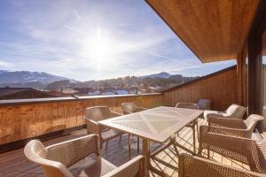 a balcony with a table and chairs and mountains at Kitzbühel Suites by ALPS RESORTS in Oberndorf in Tirol