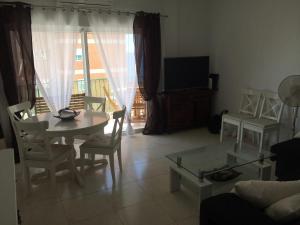 - un salon avec une table, des chaises et une télévision dans l'établissement Palasiet, à La Vila Joiosa