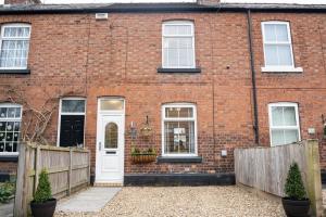 a red brick house with a white door at Well decorated 2 bed home in Handbridge, Chester in Hough Green