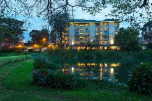 a hotel with a pond in front of a building at Qaribu Inn Boutique Hotel Nairobi in Nairobi