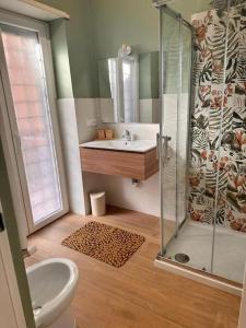 a bathroom with a glass shower and a sink at Tintarella da Monica in Lido di Ostia