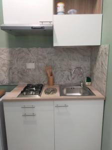 a kitchen with a sink and a stove at Tintarella da Monica in Lido di Ostia