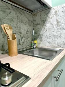 a kitchen counter with a sink and a knife block at Tintarella da Monica in Lido di Ostia