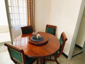 een houten tafel en stoelen in een kamer met een tafel en een tafel bij 3 Bedroom Laneens Nest in Nakuru