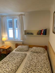2 Betten in einem kleinen Zimmer mit Fenster in der Unterkunft Weingut Martinshof in Sankt Ulrich