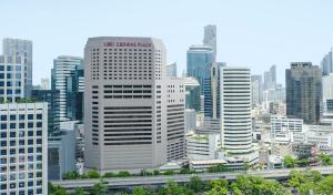 um horizonte urbano com edifícios altos e uma auto-estrada em Crowne Plaza Bangkok Lumpini Park, an IHG Hotel em Bangkok