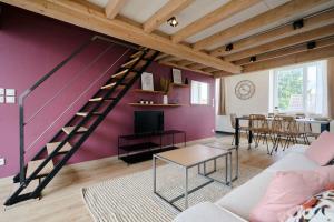 a living room with a purple wall and a staircase at Appartement 2 chambres de caractère. in La Madeleine