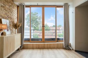 une pièce avec une grande fenêtre avec vue dans l'établissement Appartement 2 chambres de caractère., à La Madeleine