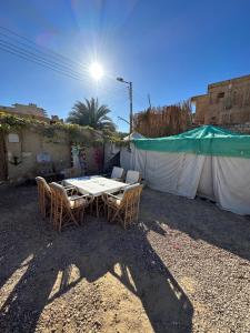 a table and chairs sitting in a yard at Muhra Camp Siwa in Siwa