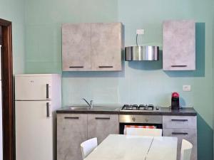 een keuken met een fornuis en een witte koelkast bij Zoe Recidencias 2 in Boves