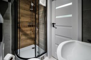 a bathroom with a shower and a white toilet at RentPlanet - Apartamenty Krasińskiego in Wrocław