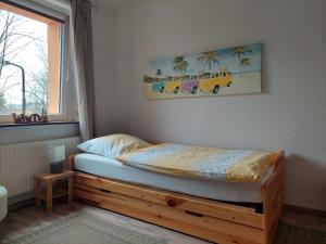Cette chambre comprend un lit avec un cadre en bois et une fenêtre. dans l'établissement Ferienwohnung Beate, à Kurort Oberwiesenthal