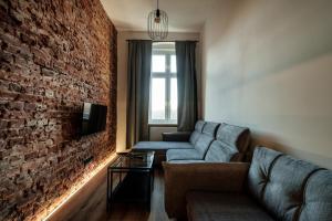 a living room with a couch and a brick wall at RentPlanet - Apartamenty Krasińskiego in Wrocław