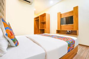 um quarto de hotel com uma cama e uma televisão em FabHotel Cozy Inn em Mumbai