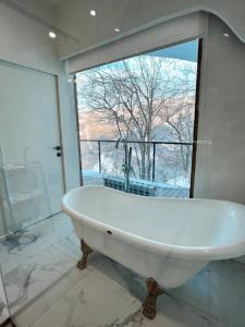 un bagno con vasca e ampia finestra di Apple Resort a Almaty