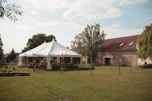 una tenda bianca in un cortile accanto a un edificio di Statek u Kapličky a Nová Ves pod Pleší