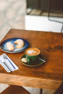 a cup of coffee and a plate of cookies on a table at Çınar Butik Hotel in Kaş