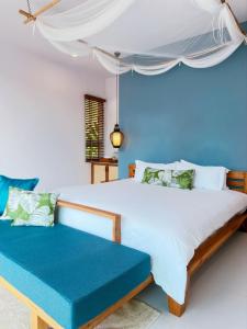 1 dormitorio con 1 cama grande y pared azul en Krabi Home Resort, en Tab Kaek