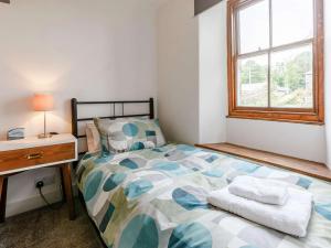 een slaapkamer met een bed, een bureau en een raam bij 2 bed in Padstow 83130 in Little Petherick