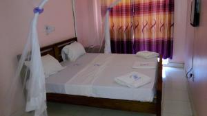 una camera da letto con un letto e asciugamani bianchi di Checkpoint Inn Hotel, Mombasa a Mombasa