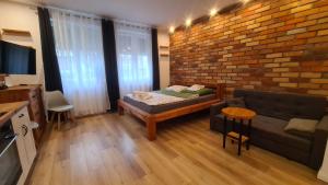 a living room with a couch and a brick wall at Solanki Loft in Inowrocław