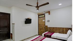 a bedroom with two beds and a ceiling fan at Hotel Cottage Crown Plaza By My Rooms in New Delhi