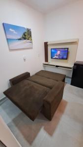 ein Wohnzimmer mit einem Sofa und einem Flachbild-TV in der Unterkunft Flats Praia Dourada in Maragogi