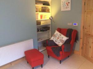 uma sala de estar com uma cadeira vermelha e um candeeiro em Castle Ivy Lodge em Cashel