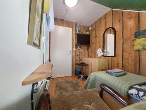 Habitación pequeña con cama y espejo. en 120 yrs. old log house in Kuopio city centre, en Kuopio