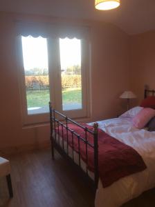a bedroom with a bed and two large windows at Castle Ivy Lodge in Cashel