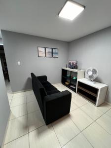 a living room with a black couch and a table at Apartamento em condomínio in Petrolina