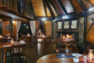 Tsitsikamma Lodge & Spa في ستورمزريفير: مطعم بطاولات وكراسي ومدفأة