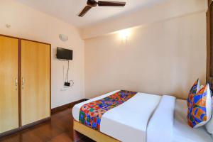ein Schlafzimmer mit einem Bett und einem TV an der Wand in der Unterkunft FabExpress Krishna in Kalkutta