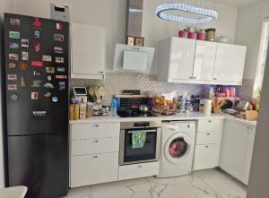 eine Küche mit einem Kühlschrank und einer Waschmaschine in der Unterkunft Diva lux in Brüssel