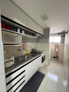 uma cozinha com um lavatório e um micro-ondas em Apartamento em condomínio em Petrolina