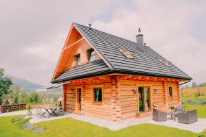 a log cabin with a black roof at Leśny Zakątek in Jurków