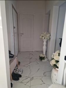 un pasillo con una puerta blanca y un jarrón de flores en Diva lux, en Bruselas