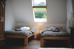 2 łóżka pojedyncze w pokoju z oknem w obiekcie Leśny Zakątek w mieście Jurków